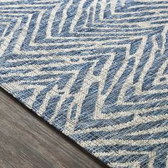 a blue and white area rug on top of a wooden floor next to a wood floor