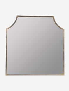 a mirror that is sitting on top of a white wall with a gold trim around the edge