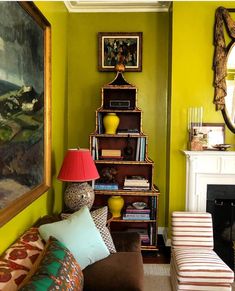 a living room filled with furniture and a fire place under a painting on the wall