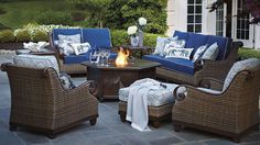 an outdoor patio with wicker furniture and fire pit