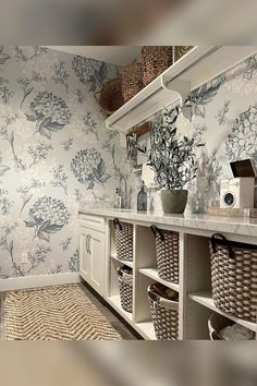 a bathroom with floral wallpaper and baskets on the counter