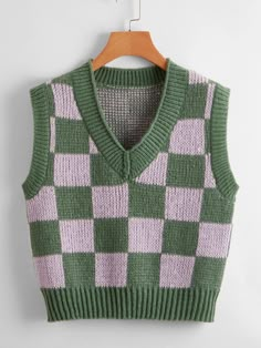 a green and pink sweater vest hanging on a hanger