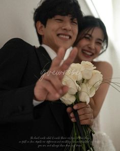 a man and woman posing for the camera with flowers in front of their faces as if they were just getting married