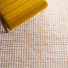 a yellow chair sitting on top of a rug