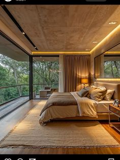 a large bed sitting in the middle of a bedroom next to a wooden floor and windows