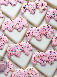 many decorated heart shaped cookies with sprinkles