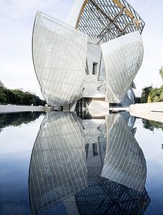 an artistic building is shown with its reflection in the water and it's architecture