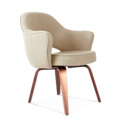 an upholstered chair with wooden legs and a beige fabric seat pad on the back