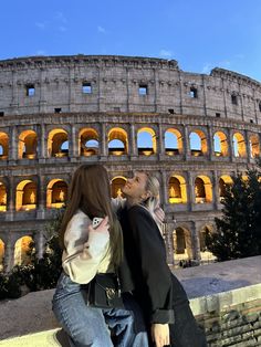 two people standing in front of an old building