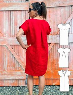 a woman standing in front of a wooden fence with her back to the camera, wearing a red dress