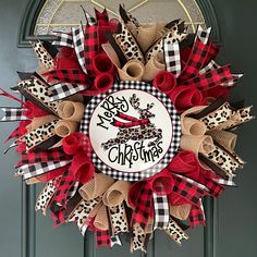 a red and black wreath with the words merry christmas on it hanging from a door