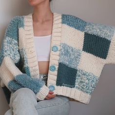 a woman sitting on the floor wearing a blue and white checkered cardigan sweater