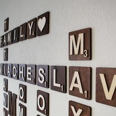 the word family spelled with wooden letters on a white wall next to other words that spell out their names