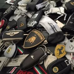 a pile of assorted key chains and other car emblems on top of each other