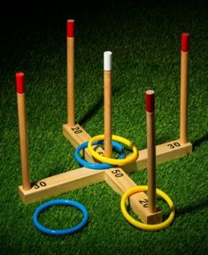 four wooden rings and two colored circles on the grass with numbers in front of them