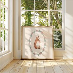 a bear is sitting in the middle of a room with a framed photo on the floor