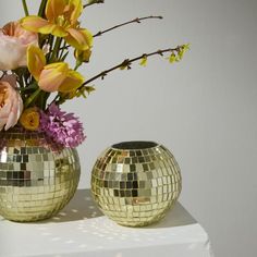 two vases with flowers in them sitting on a table