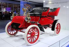 an old fashioned red and black car on display