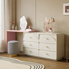 a white dresser sitting in a bedroom next to a window