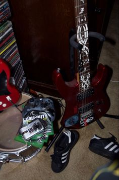 a red guitar and other musical equipment on the floor