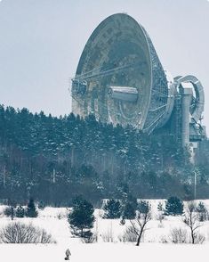 a large satellite dish sitting on top of a snow covered field