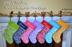 six christmas stockings hanging from a mantel with the words simply modern monochromatic stockings