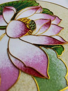 a close up view of a flower on a plate with gold and green trimmings