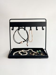 an assortment of jewelry is displayed on a black tray