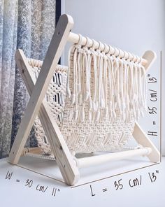 a white chair sitting on top of a table next to a window with curtains behind it