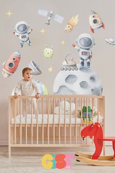 a baby in a crib with space themed wall decals