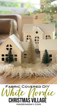 a white house with christmas trees in the foreground and text overlay that reads fabric covered diy white nordic christmas village