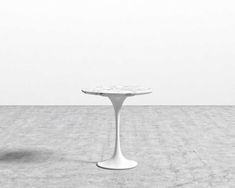 a white table sitting on top of a cement floor