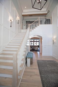 a large white staircase leading up to a living room