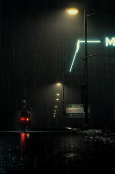 a person riding a motorcycle in the rain at night with an arrow sign above them