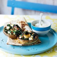 a blue plate topped with a pita sandwich next to a bowl of yogurt