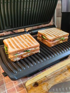 two grilled sandwiches sitting on top of a grill