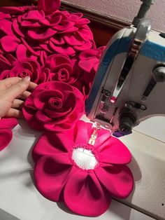 a person is using a sewing machine to sew flowers