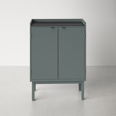 a gray cabinet sitting on top of a white floor