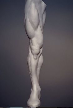 a white statue is standing in front of a gray background and has his legs spread out