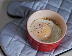 an egg is in a red bowl on a blue mat