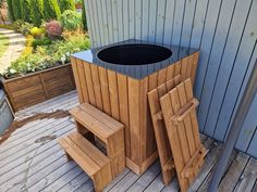 a trash can sitting on top of a wooden deck next to a planter and bench