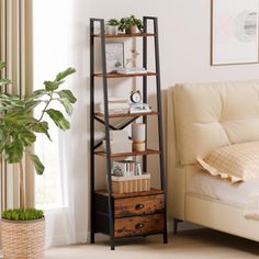 a living room with a white couch and a book shelf next to a plant in a pot