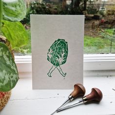 a card with an image of a woman holding a tree in her hands and two pair of scissors next to it