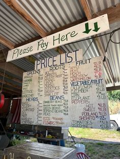 a sign that says please pay here and price list hanging from the side of a building