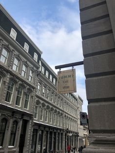 a street sign hanging from the side of a tall building next to a traffic light