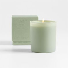 a white candle sitting next to a green box