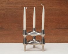 three candles are placed in a metal holder