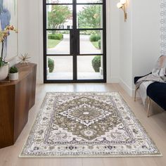 a living room with a large rug on the floor and an open door leading to another room