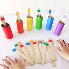 children's hands holding wooden toothbrushes in different colors