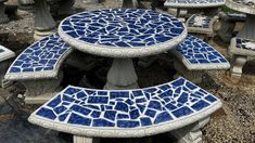 several blue and white benches sitting next to each other on top of a gravel ground